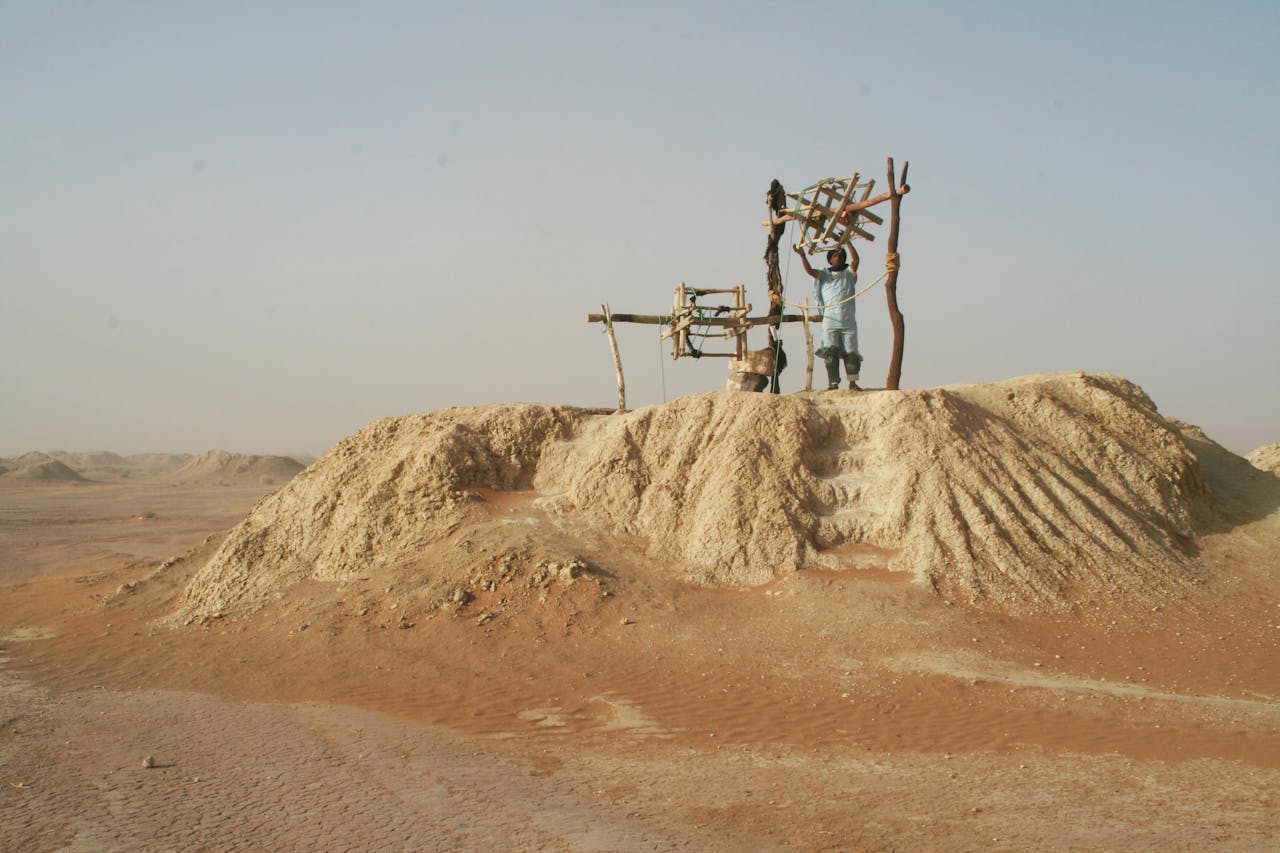 A man working on a traditional mining setup in the arid landscape of Morocco's Draa-Tafilalet.